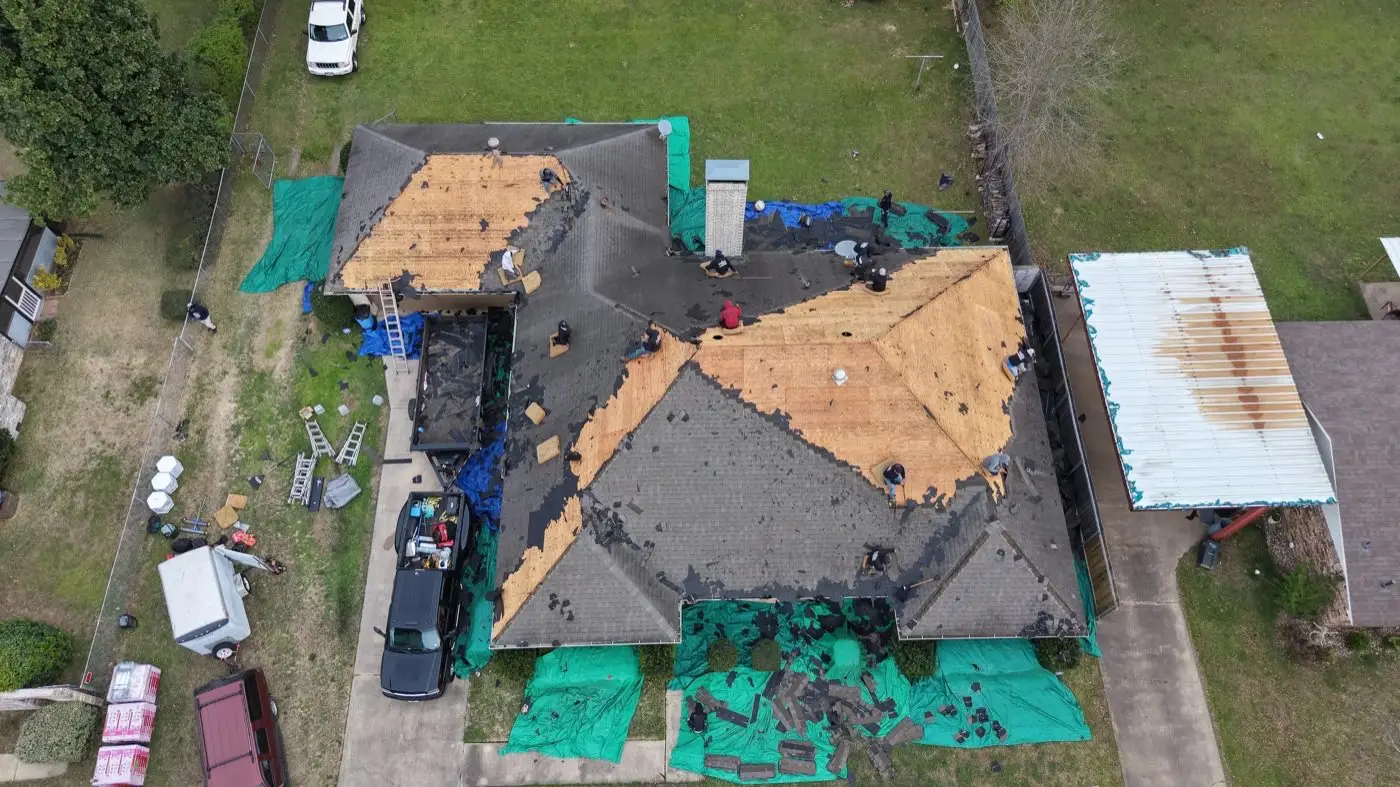 Bohon crew tearing off and re-decking a roof, with tarps protecting the yard