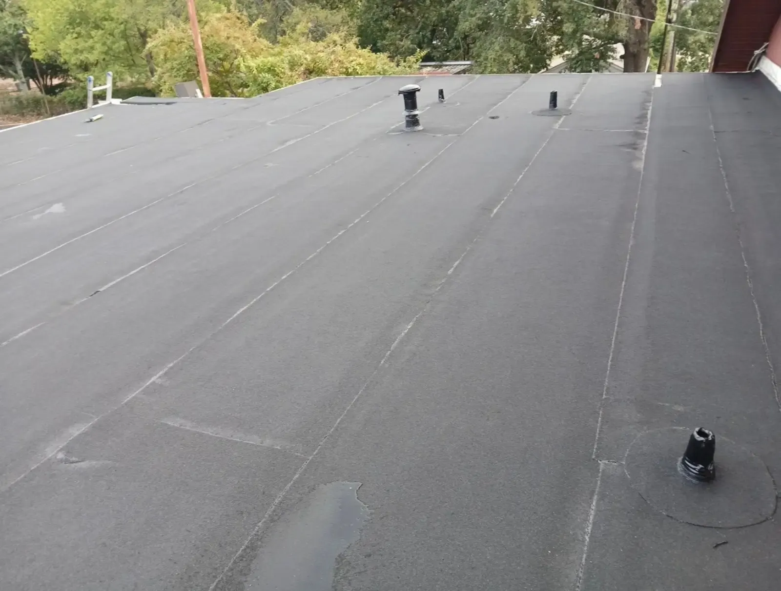 Finished low-slope roof with sealed flashings around each pipe