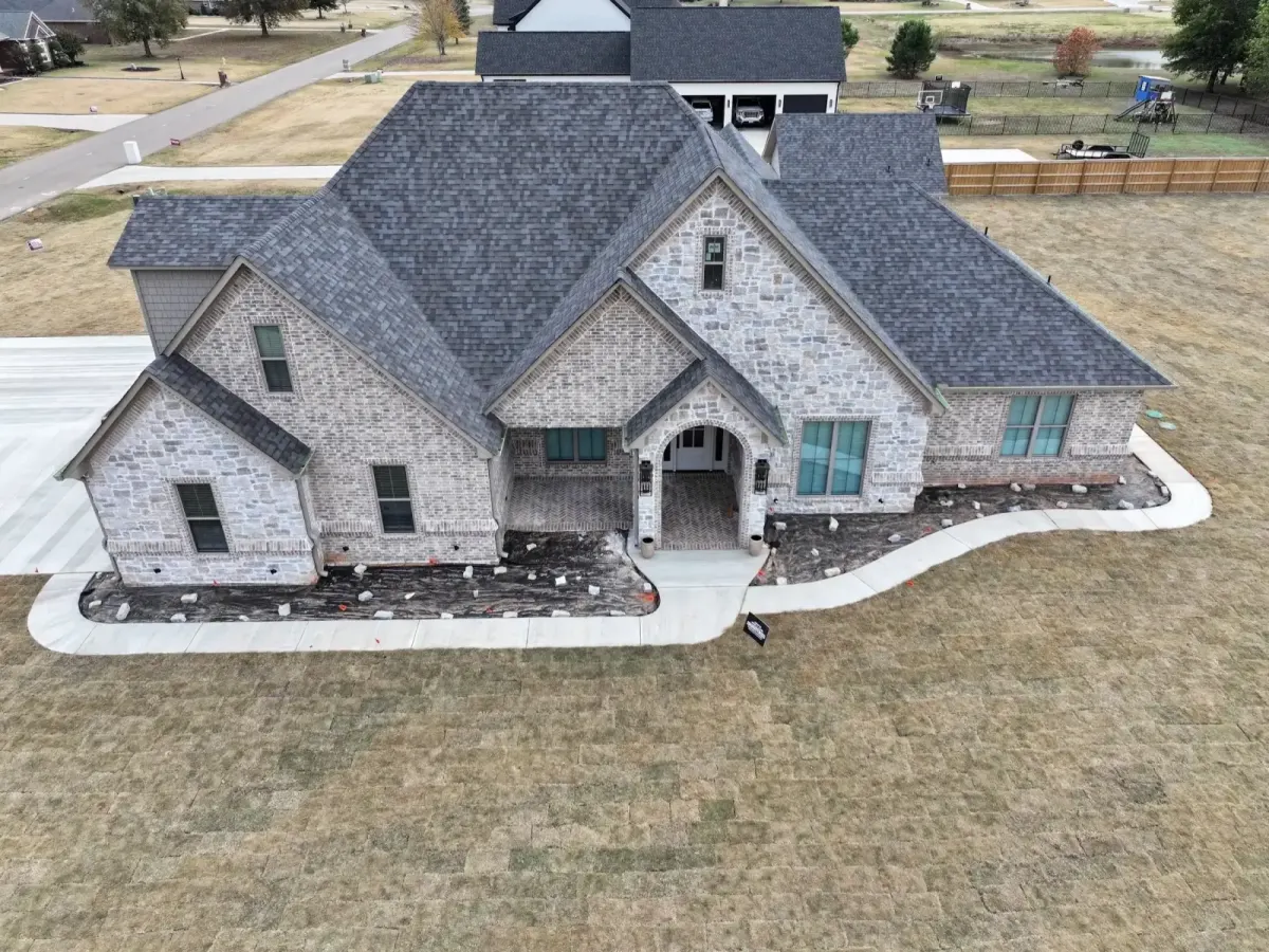 Aerial view of a stone home with a new charcoal architectural shingle roof