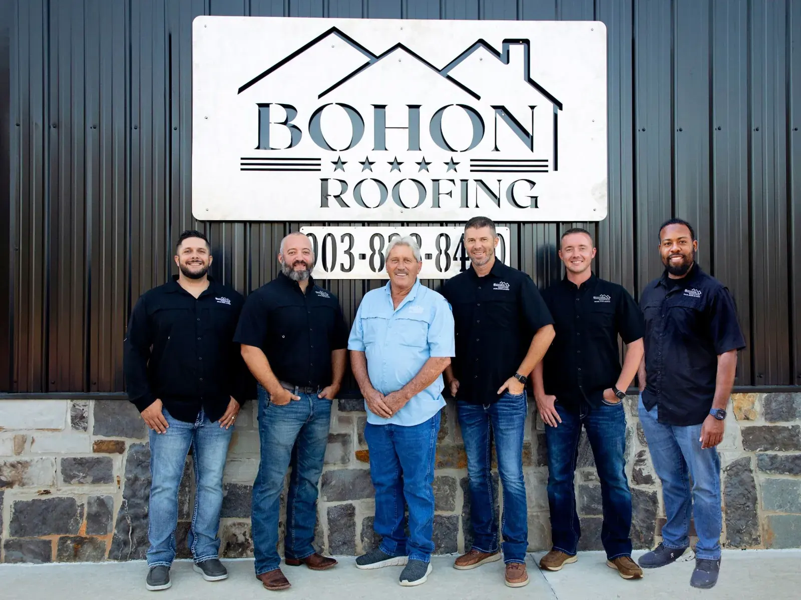The Bohon Roofing crew under the sign at the shop, left to right: Ted Turner, Jake Casteel, James Bohon, Robbie Bohon, Dalton Crouch, and Cameron Hunt