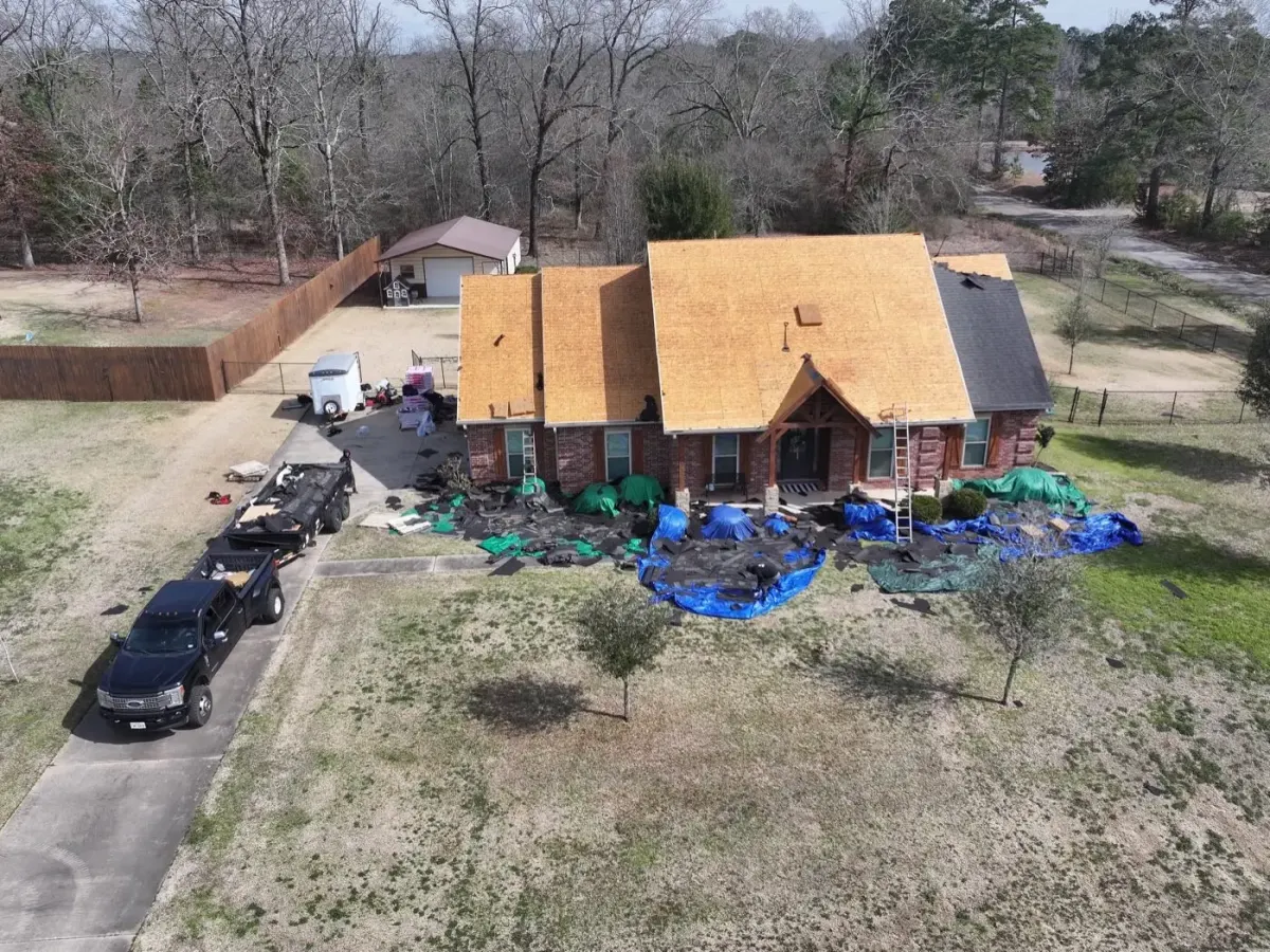 Brick home with new decking installed and the yard fully tarped